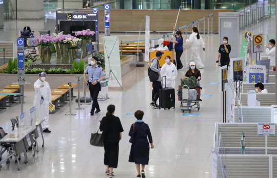 국내 코로나19 신규 확진자 수가 확산세를 이어가는 가운데 지난달 23일 인천국제공항 제1여객터미널 입국장에서 해외입국자들이 이동하고 있다. <연합뉴스>